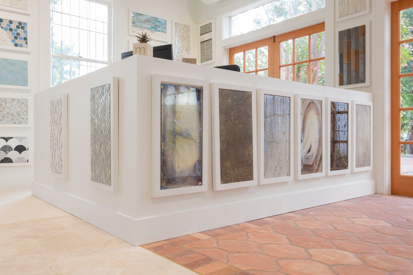 a white desk area with picture frames around it