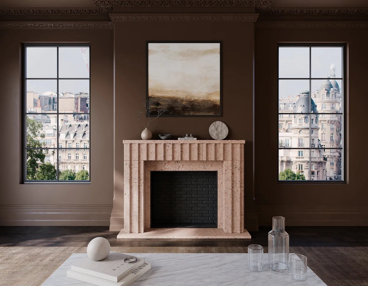 An orange adoquin fireplace against a brown wall. There is a painting above the fireplace and a large window on either side of it. There is a white marble coffee table in the foreground.