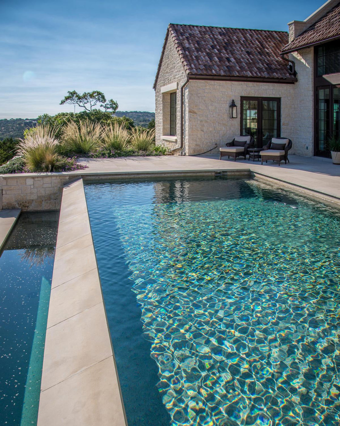 a house pool with tan limestone coping and decking tile