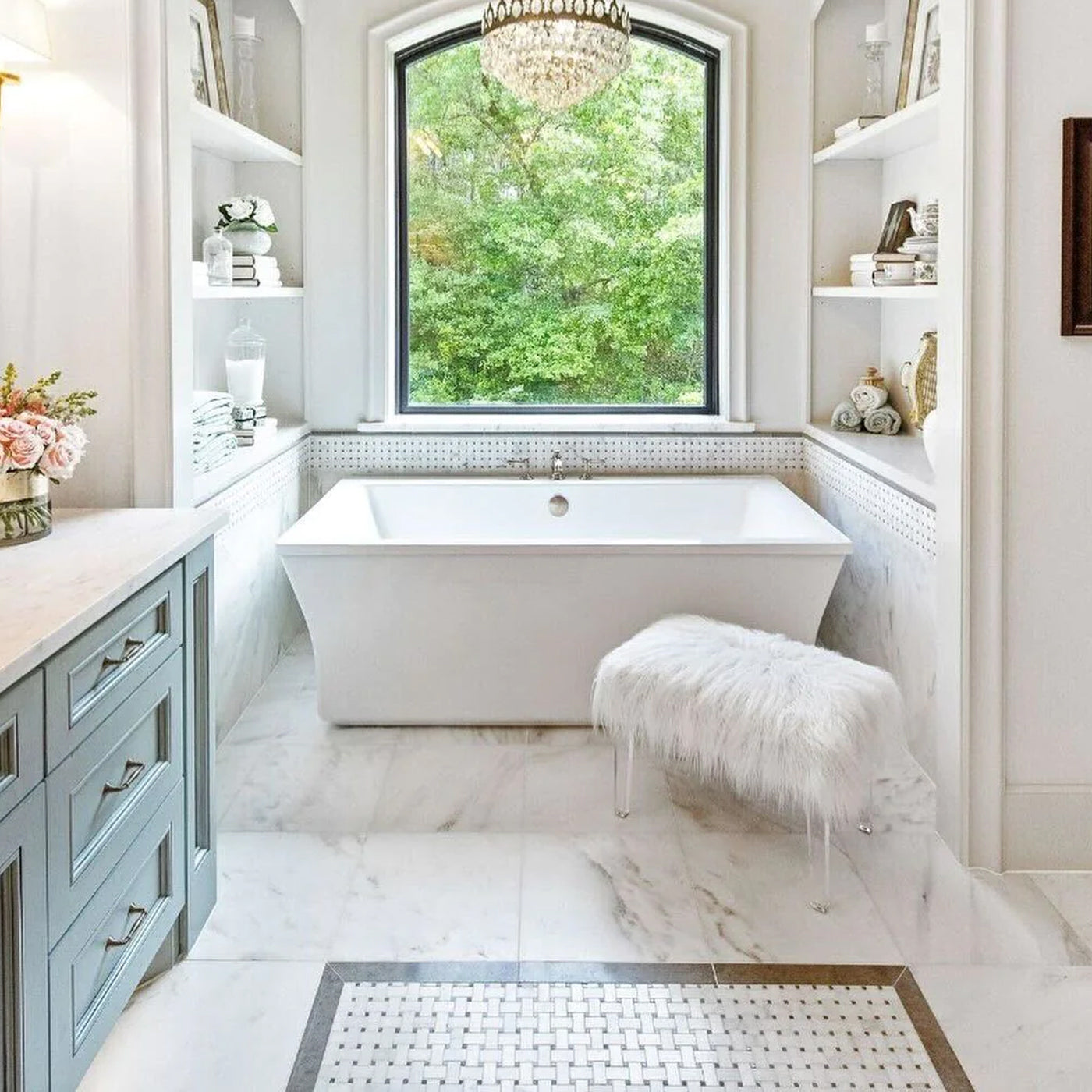 white bathtub on a white marble tiled floor in the bathroom