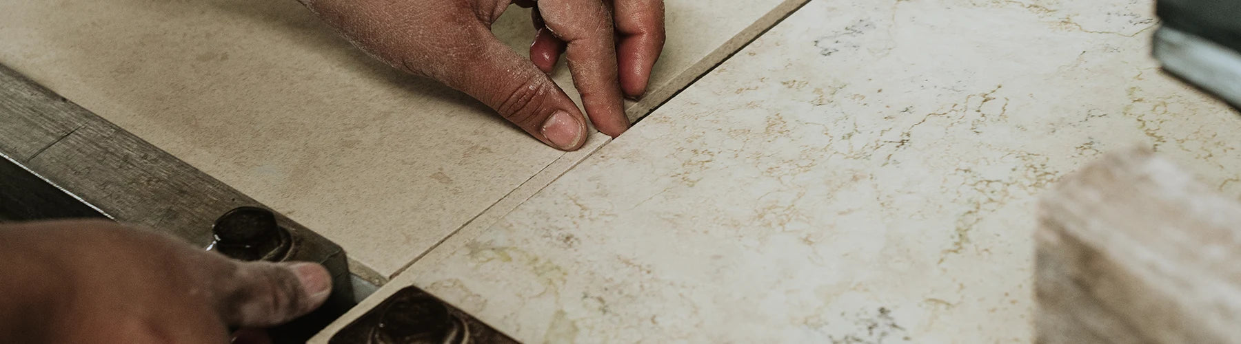 A craftsman carefully aligns two pieces of material on a workbench, ensuring a precise fit while working on a project.