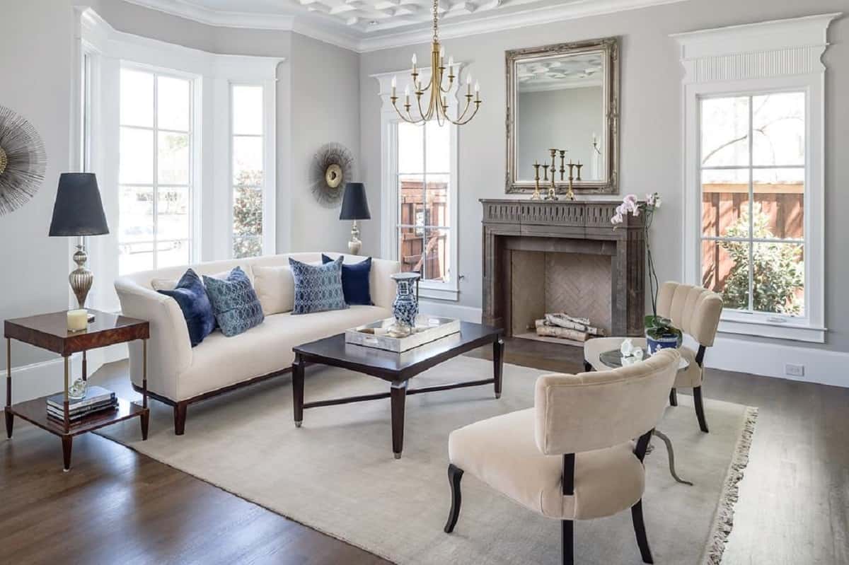 a living room with a black fireplace, coffee table, and chairs and couches on a rug