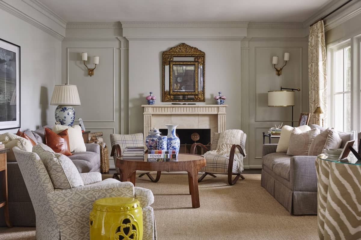 a decorative living room with couches and chairs and a white fireplace