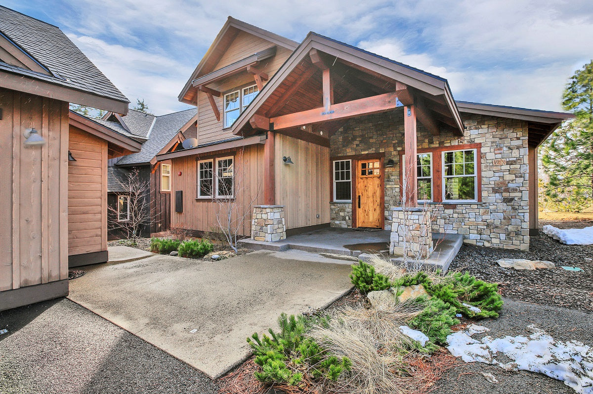 A wooden house with stone walls, front door view